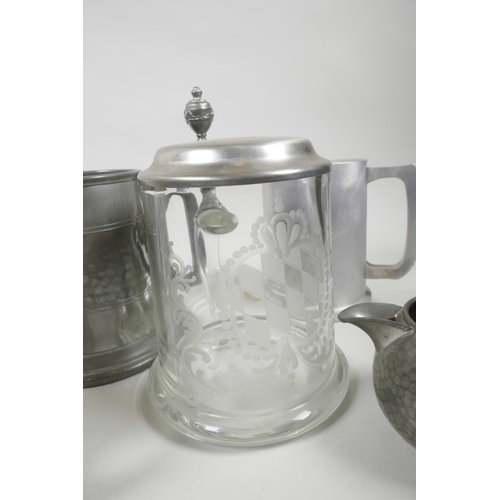 42 - Five pewter tankards, a pewter cream jug and an engraved glass tankard with pewter lid, 6½