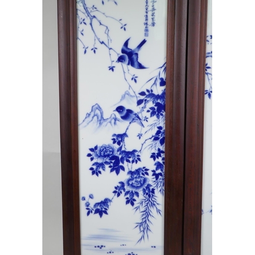 43 - A pair of Chinese blue and white porcelain panels in hardwood frames, decorated with birds amongst f... 