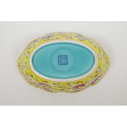 53 - A Chinese porcelain dish with blue and pink enamel dragon decoration on a yellow field, four charact... 