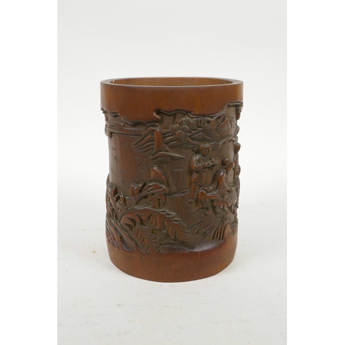 70 - A Chinese carved bamboo brush pot decorated with figures in a landscape, 6½