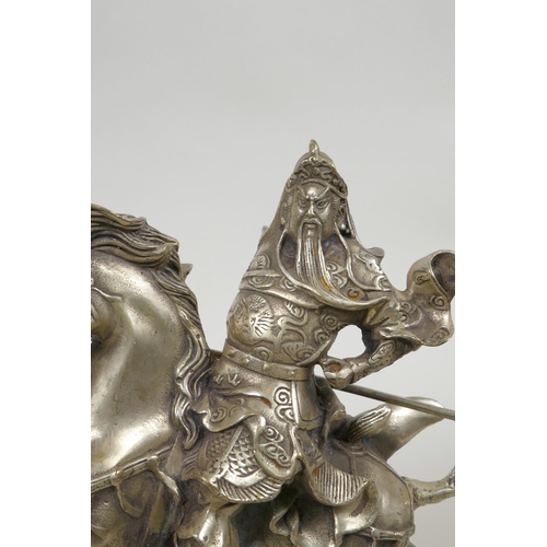 55 - A Chinese silvered metal figure of Guan Gong riding a horse, 7½