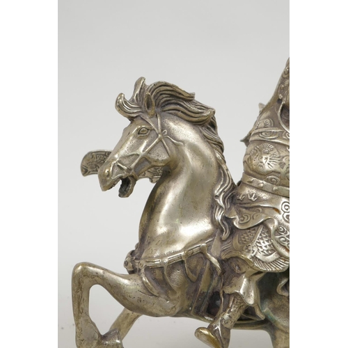 55 - A Chinese silvered metal figure of Guan Gong riding a horse, 7½