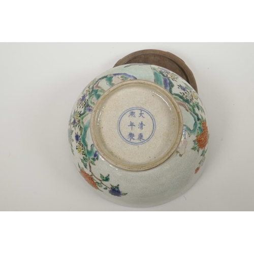 58 - A Chinese crackleware bowl with famille verte decoration of birds in a landscape, on a carved hardwo... 