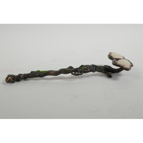 61 - A Chinese bronze ruyi in the form of a branch, set with green and white stones, 10½