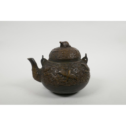 18 - A Chinese bronze teapot with raised decoration of cranes in flight, four character mark to base, 5½