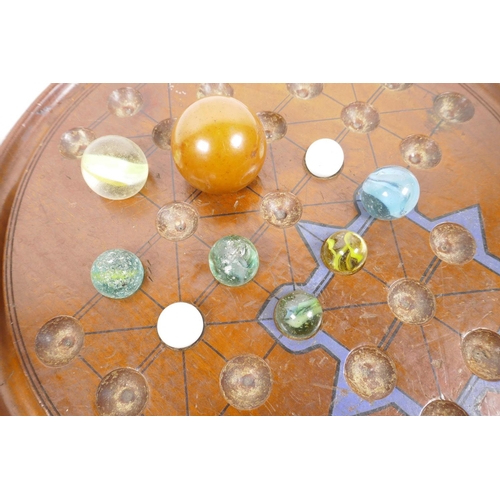 55 - A large wooden solitaire board, A/F, together with a quantity of vintage marbles