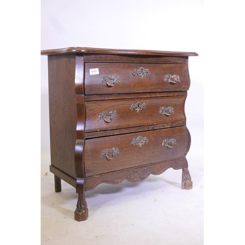 1171 - An oak Dutch style bombe fronted three drawer chest, with shaped top, raised on carved supports, 26