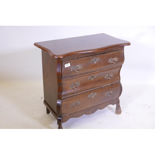 1171 - An oak Dutch style bombe fronted three drawer chest, with shaped top, raised on carved supports, 26