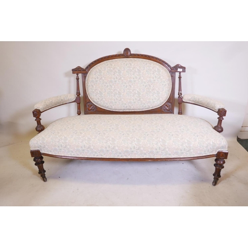 1176 - A Victorian walnut open arm settee with carved decoration and bow front, raised on turned, fluted su... 