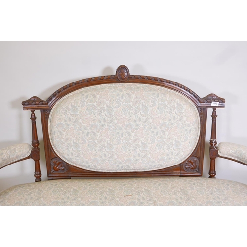 1176 - A Victorian walnut open arm settee with carved decoration and bow front, raised on turned, fluted su... 