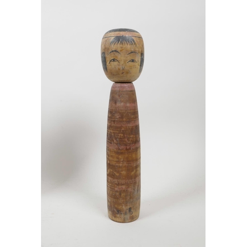 21 - A collection of four Japanese carved and turned wood Kokeshi dolls, signed to the base and sides, 9½... 