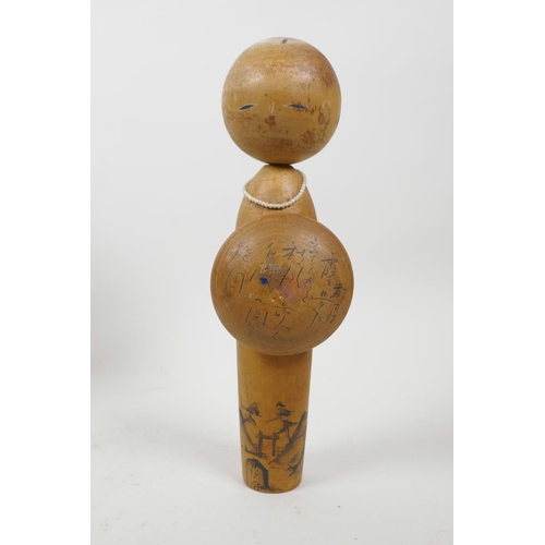 21 - A collection of four Japanese carved and turned wood Kokeshi dolls, signed to the base and sides, 9½... 