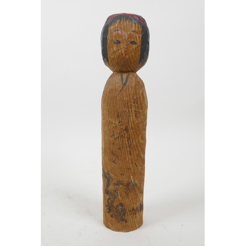 21 - A collection of four Japanese carved and turned wood Kokeshi dolls, signed to the base and sides, 9½... 