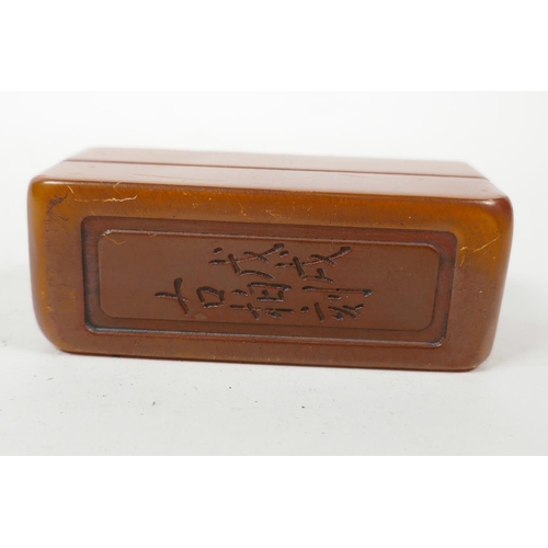 25 - A Chinese amber soapstone box containing a soapstone seal, the cover decorated with carved character... 