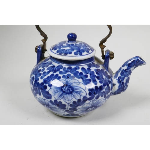 30 - A small Chinese blue and white porcelain teapot with floral decoration and metal handle