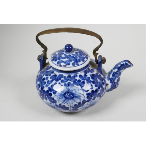 30 - A small Chinese blue and white porcelain teapot with floral decoration and metal handle