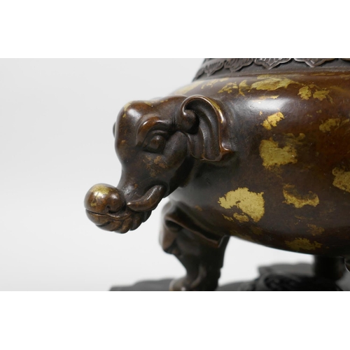 33 - A Chinese bronze censer and pierced cover on tripod supports, with two elephant mask handles and gil... 