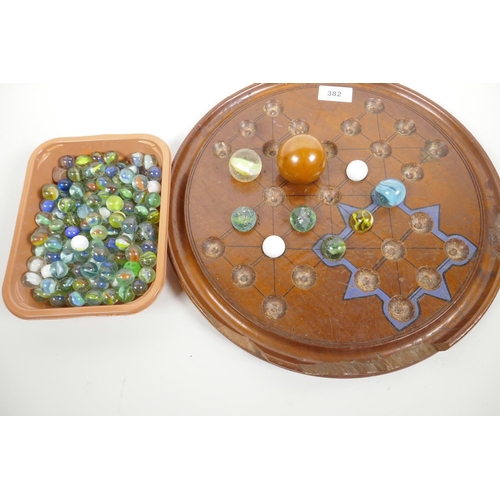 55 - A large wooden solitaire board, A/F, together with a quantity of vintage marbles