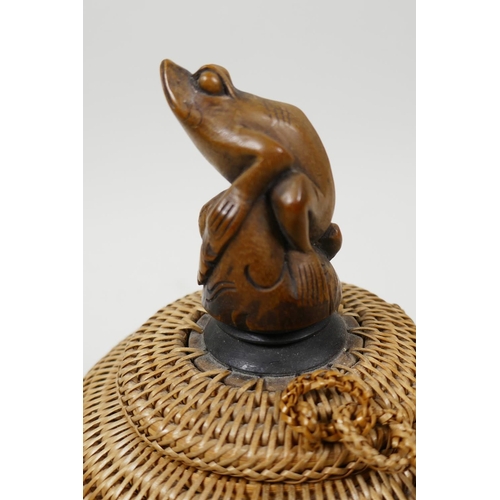 66 - A small Japanese basketwork pot and cover with turned wood pedestal base and carved knop in the form... 