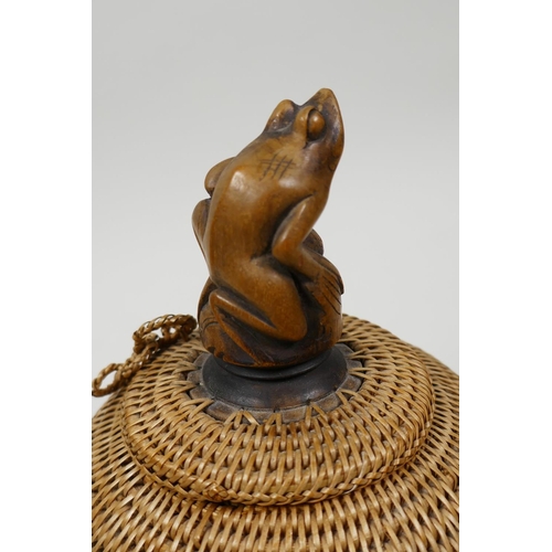 66 - A small Japanese basketwork pot and cover with turned wood pedestal base and carved knop in the form... 