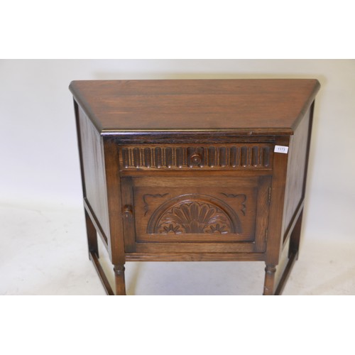 1173 - An oak credence cupboard, with single drawer over door and carved decoration, raised on turned suppo... 