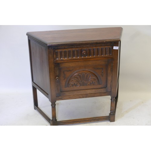 1173 - An oak credence cupboard, with single drawer over door and carved decoration, raised on turned suppo... 