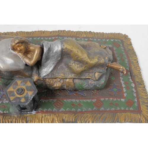 14 - A cold painted bronze figure of a girl lying on a bed, 6¼