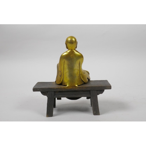 16 - A Chinese gilt bronze figure of Buddha seated on a bench, 5½