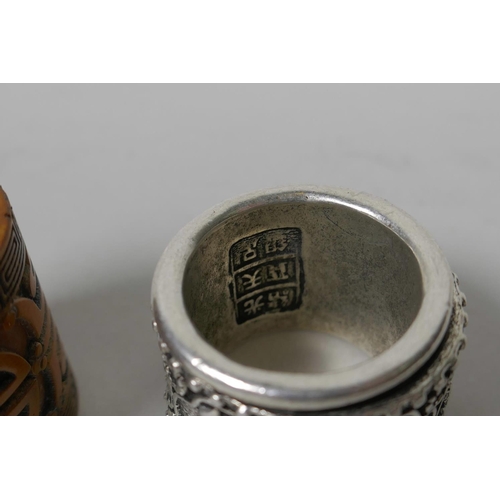 18 - A Chinese white metal archer's thumb ring with a revolving cuff, together with a carved thumb ring d... 