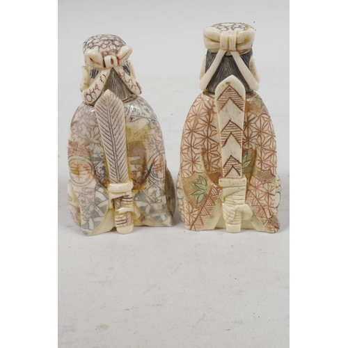 31 - A pair of Chinese bone snuff bottles in the form of two dignitaries, with inked engraved decoration,... 