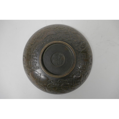 48 - A Chinese bronze trinket bowl with raised kylin decoration, 4 character mark to base, 7