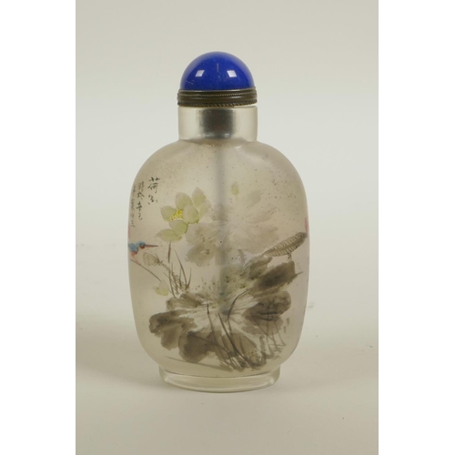 28 - A Chinese reverse decorated glass snuff bottle depicting figures and birds in a landscape, 3½