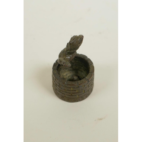 3 - An Oriental bronzed metal ornament of a cockerel standing on a well, impressed seal mark to base, 2