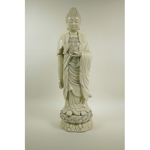 33 - A Chinese blanc de chine porcelain figure of Buddha standing on a lotus flower, impressed seal marks... 