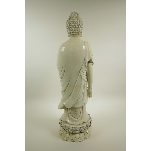 33 - A Chinese blanc de chine porcelain figure of Buddha standing on a lotus flower, impressed seal marks... 