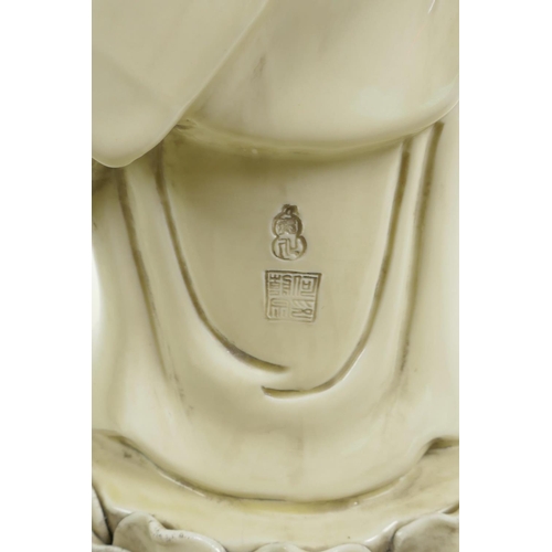 33 - A Chinese blanc de chine porcelain figure of Buddha standing on a lotus flower, impressed seal marks... 