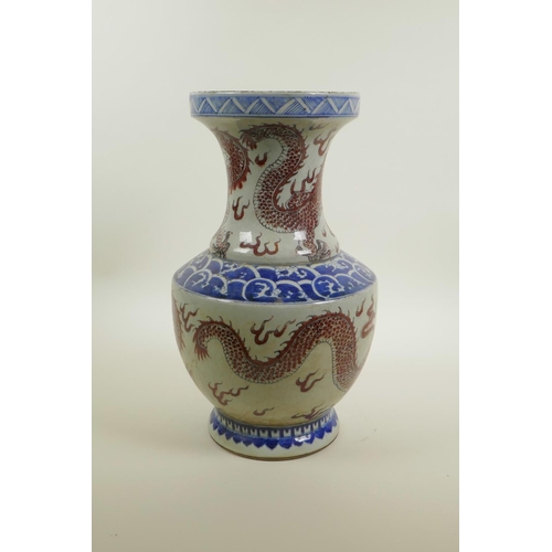 38 - A Chinese blue and white porcelain vase of waisted form with iron red dragon and flaming pearl decor... 