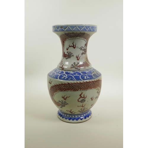 38 - A Chinese blue and white porcelain vase of waisted form with iron red dragon and flaming pearl decor... 