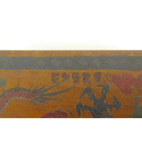 40 - A Chinese lacquer box with engraved and painted decoration of dragons chasing the flaming pearl, 12