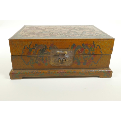 40 - A Chinese lacquer box with engraved and painted decoration of dragons chasing the flaming pearl, 12