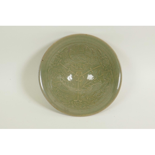 41 - A Chinese porcelain celadon glazed shallow bowl with embossed decoration of birds amongst branches, ... 