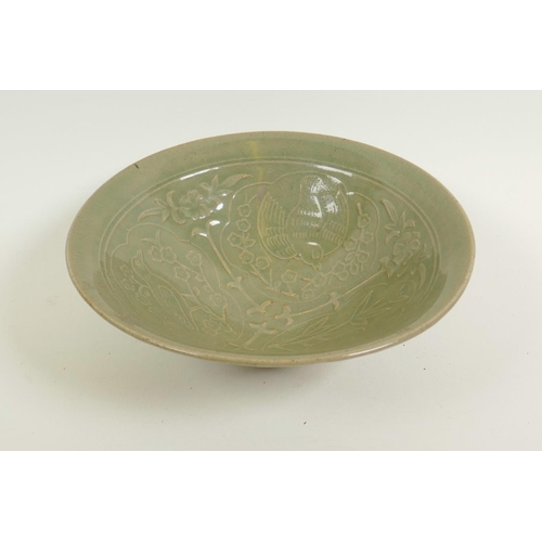 41 - A Chinese porcelain celadon glazed shallow bowl with embossed decoration of birds amongst branches, ... 