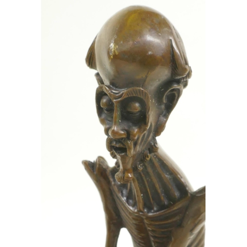 46 - A bronze figure of a skeletal man, 8½