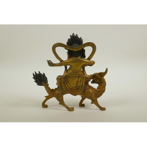 56 - A Sino-Tibetan gilt bronze of a wrathful deity riding a mythical beast, 8