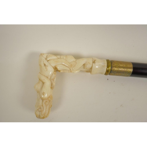 10 - A hardwood walking stick with bone handle carved as erotic figures, 36