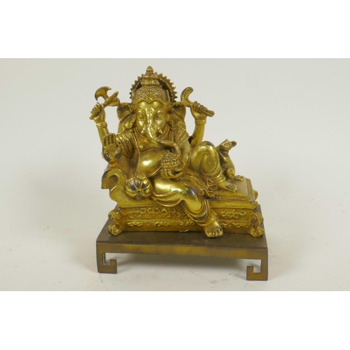 124 - A gilt bronze figure of Lord Ganesh reclining on a couch, 5