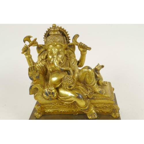 124 - A gilt bronze figure of Lord Ganesh reclining on a couch, 5