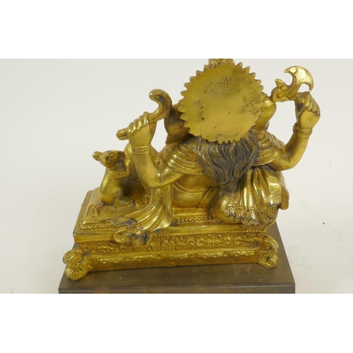 124 - A gilt bronze figure of Lord Ganesh reclining on a couch, 5