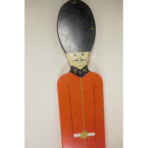 19 - A painted wood height measure in the form of a guard in ceremonial dress including busby, 48