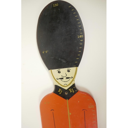 19 - A painted wood height measure in the form of a guard in ceremonial dress including busby, 48